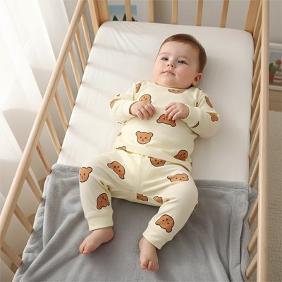 Bebe en Pyjama bebe ours-sur son dos dans son lit