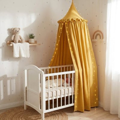 Ciel de lit jaune suspendu d'un lit de bébé