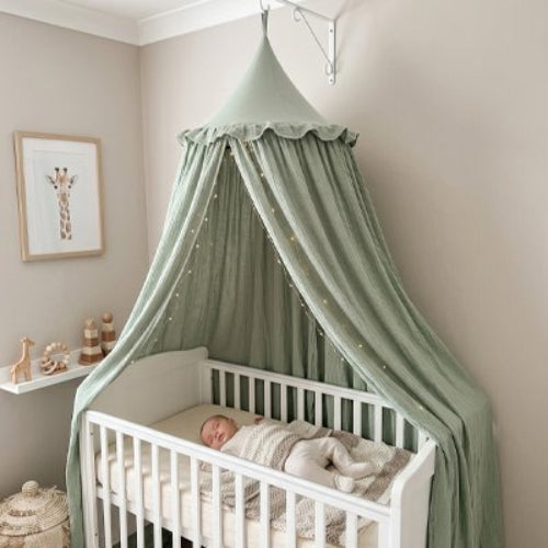 Ciel de lit vert bebe dormant confortablement