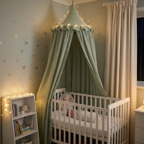 Ciel de lit vert et bébé enroulé en couverture