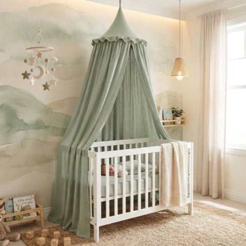 Ciel de lit vert suspendu sur le lit de bébé 