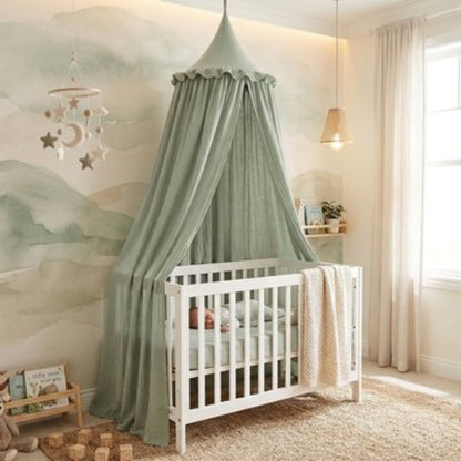 Ciel de lit vert suspendu sur le lit de bébé 