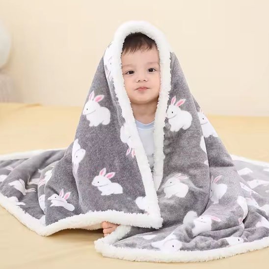 Couverture bébé en lapine étalée sur un bébé assis