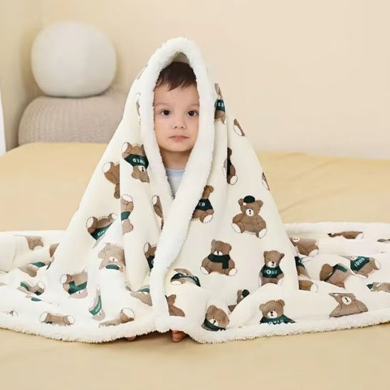 Couverture bébé en ours étalée sur un bébé assis